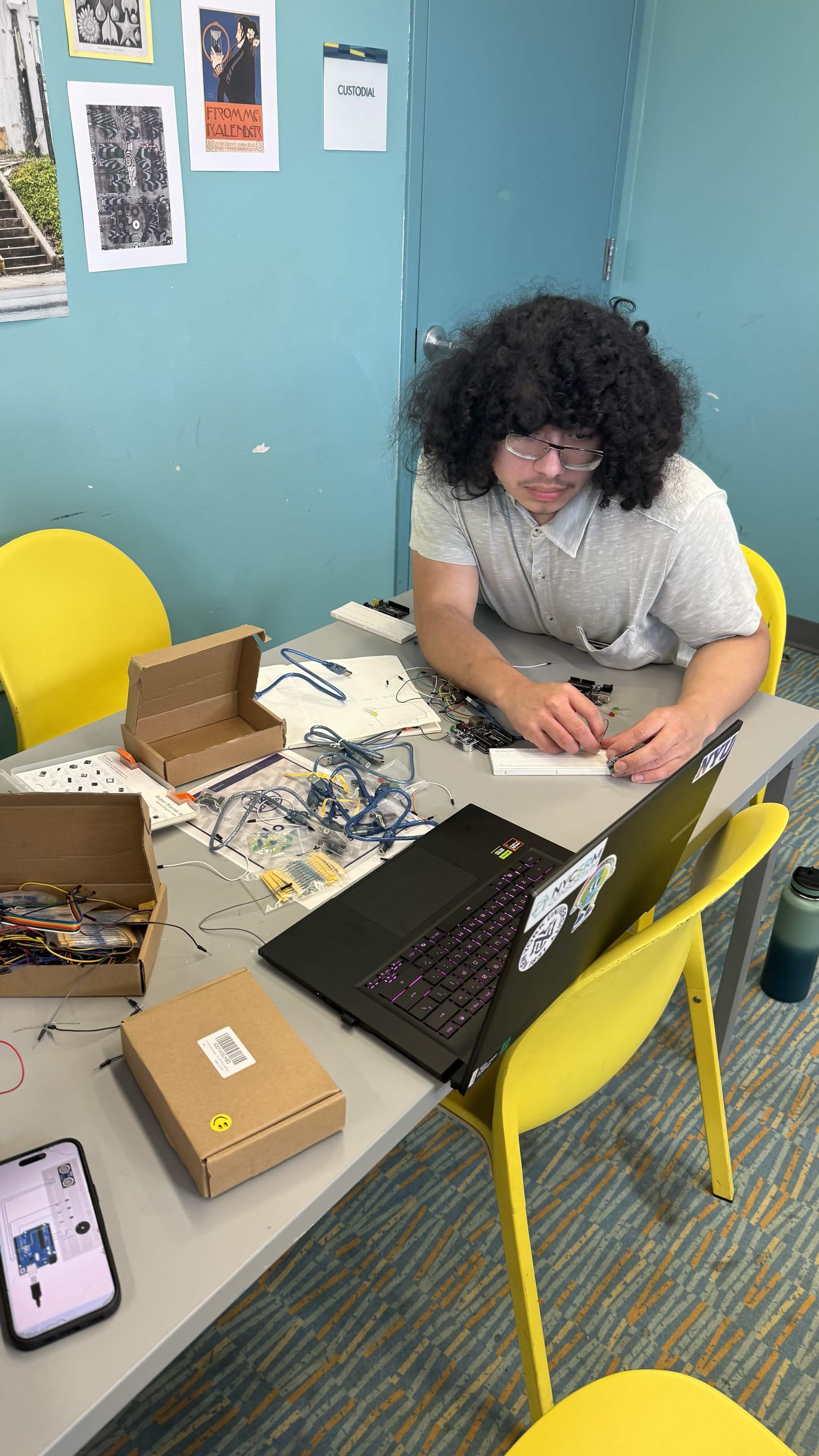 Student building a circuit with a breadboard and Arduino at a desk
